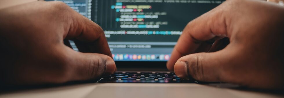 African American man sitting in front of computer coding, programming, web developer