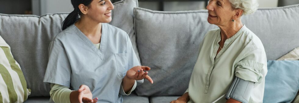 Young Nurse Talking to Senior Woman in Retirement Home